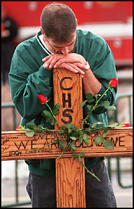 An unidentified mourner leans on a cross during the memorial service in Littleton, Colo., on April 25, 1999
